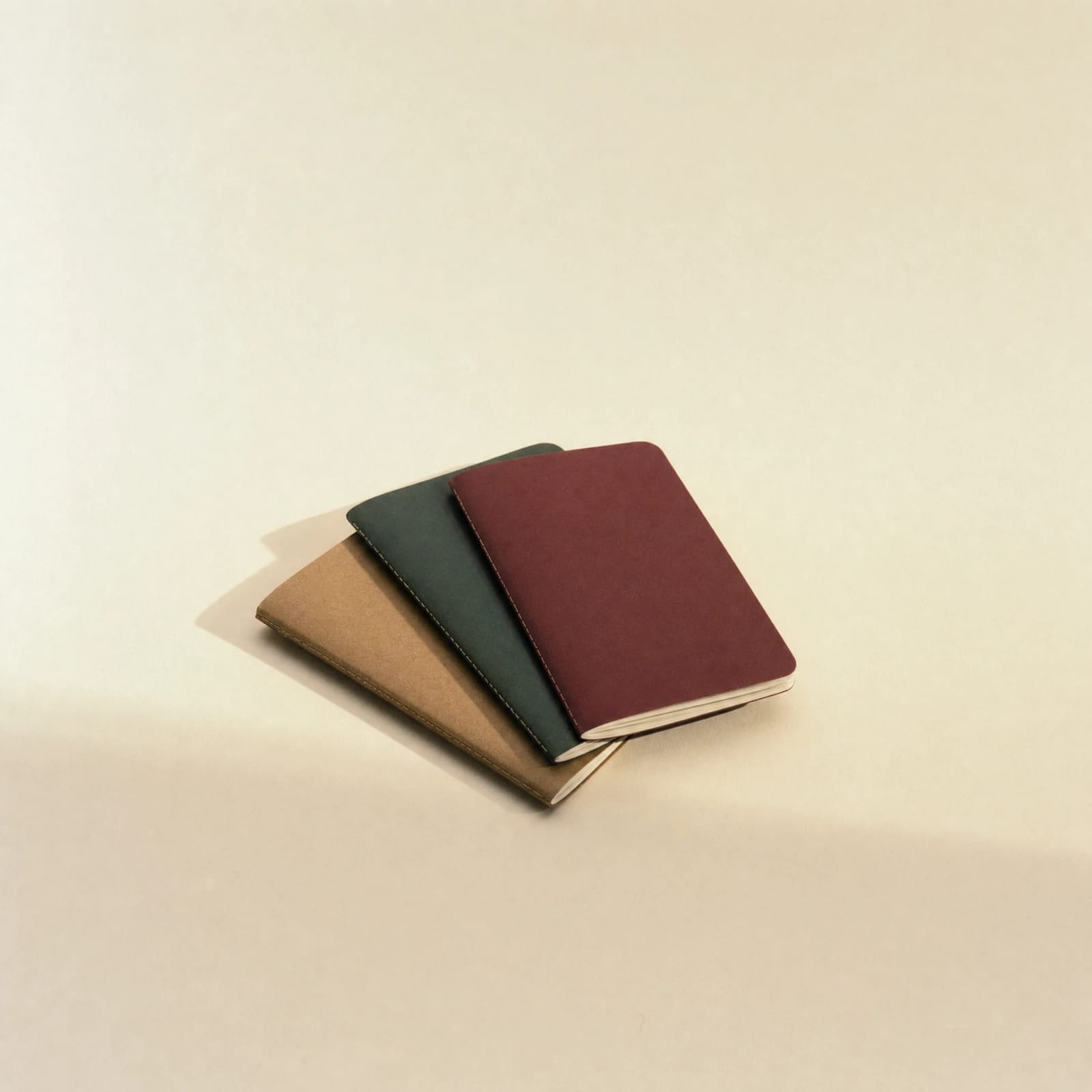 No. 07 Field Notebooks — fanned stack in oxblood, forest green, and kraft